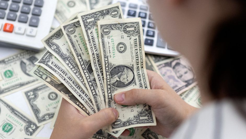 mujer-sostiene-billetes-dolar-estadunidense